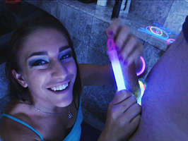 Un zorrita descarad que adora divertirse mientras hace una paja, con linternas fluorescentes alrededor del pene en la oscuridad