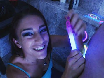 Un zorrita descarad que adora divertirse mientras hace una paja, con linternas fluorescentes alrededor del pene en la oscuridad